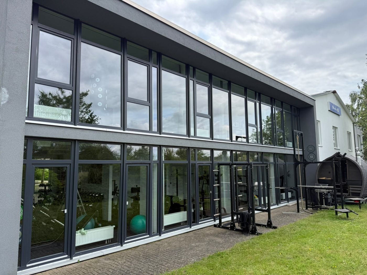 Große, frisch gereinigte Glasfront eines Fitnessstudios über zwei Etagen