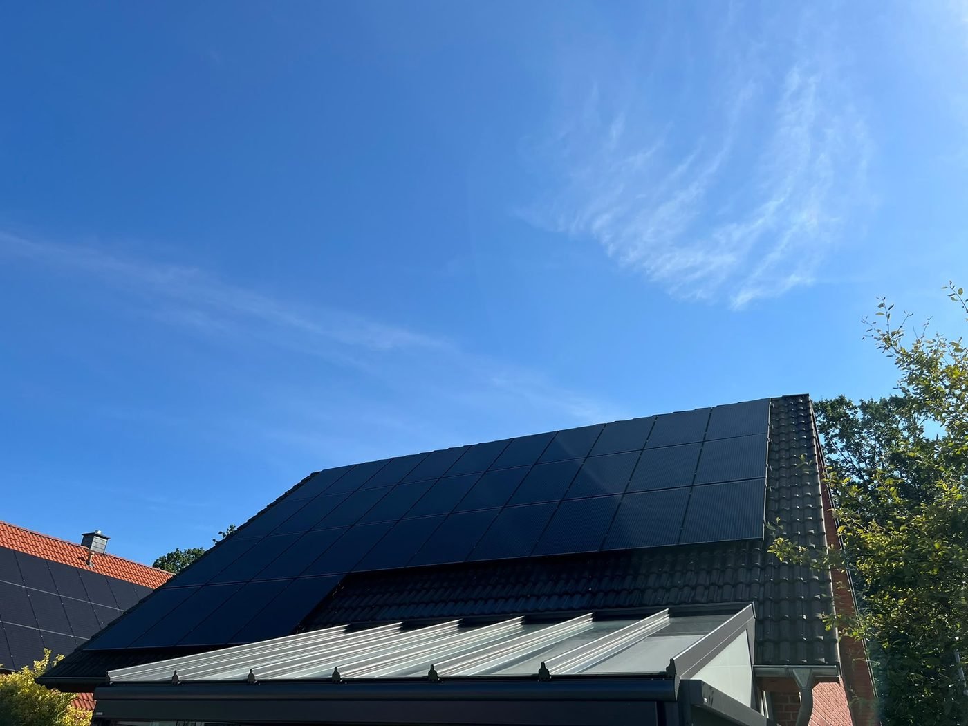Frisch gereinigte schwarze Solarmodule vor blauem Himmel